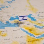 Israeli flag pinned on Middle East map.