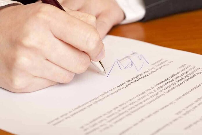 66092728 featured image Person signing a document with a pen