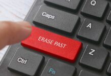Finger pressing red keyboard key erase past