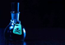 Dark bottle with skull-and-crossbones label on table