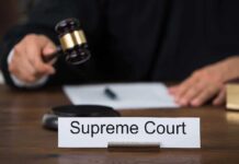 Judge with gavel and Supreme Court nameplate
