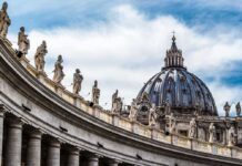 St Peter Basilica dome with statues and clouds
