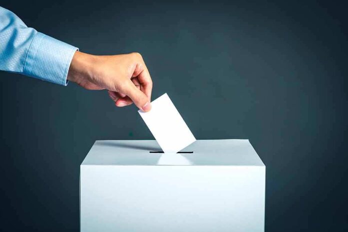 764908306 featured image Hand placing ballot into voting box