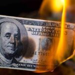 Hundred dollar bill burning with orange flames