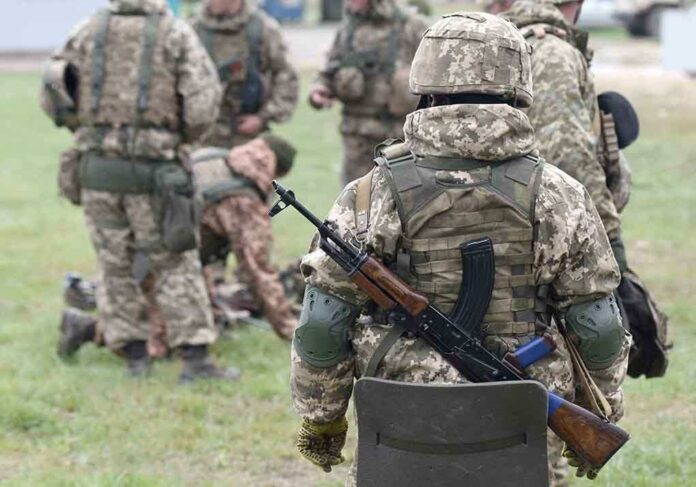 2057061182 featured image Soldiers in camouflage gear gathered on grass field.