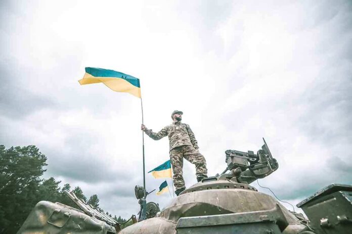 Soldier on tank holding Ukrainian flag
