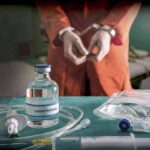 Handcuffed person with sodium thiopental on table.