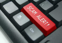 Close-up of keyboard with red "SCAM ALERT" key.