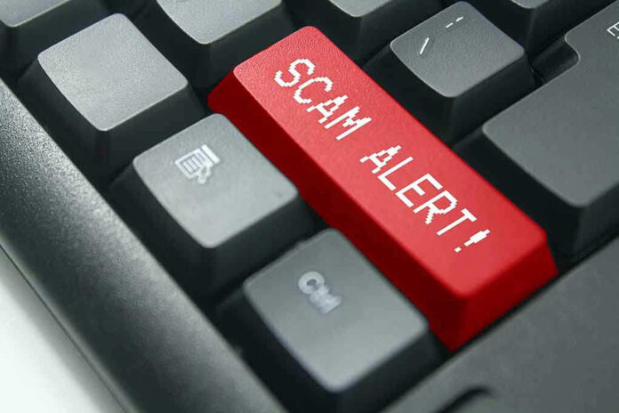 1013735752 Close-up of keyboard with red "SCAM ALERT" key.