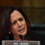 Woman speaking into a microphone while frowning