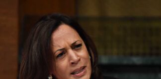Woman speaking into a microphone while frowning