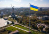 Large Ukraine flag with cityscape in background