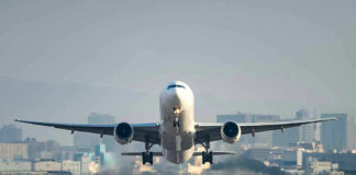 Airplane taking off from runway in urban area
