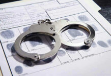 Handcuffs on fingerprint form with fingerprints visible