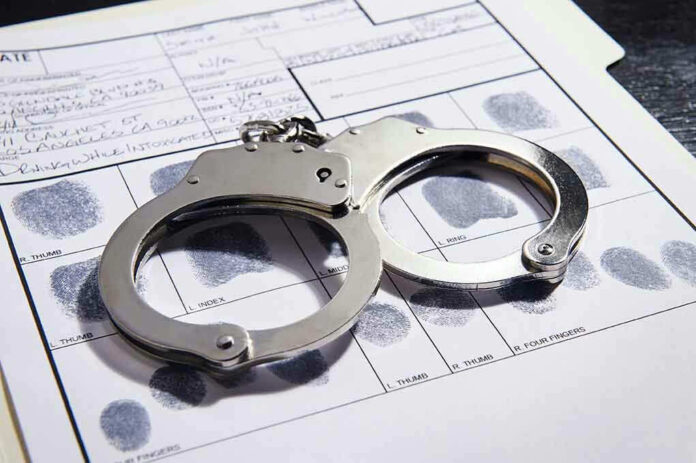 Handcuffs on fingerprint form with fingerprints visible