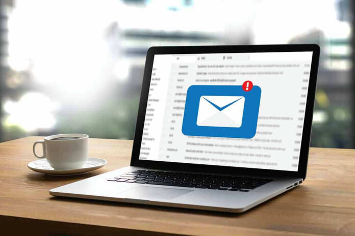 662220520 Laptop with email notification on screen at desk