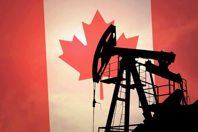 shutterstock_290285582.jpg Silhouette of an oil rig against the Canadian flag