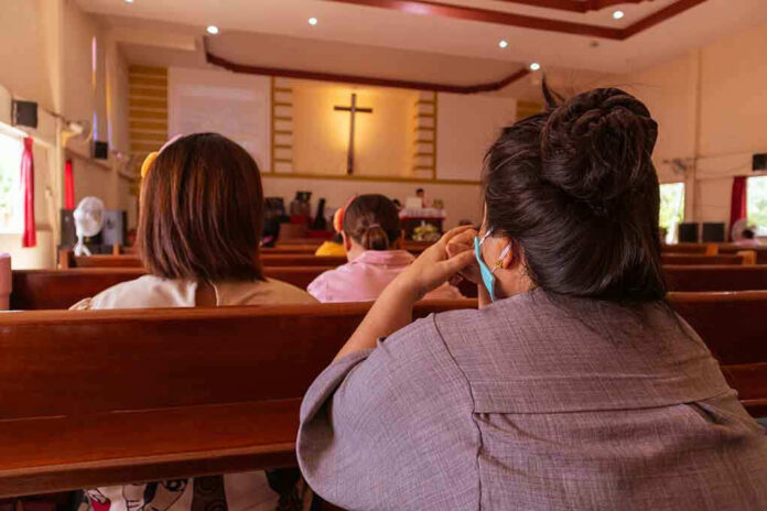 People sitting in church pews during service