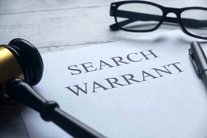 Search warrant document with gavel and glasses