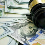 Shocking Power Grab Targets Abuse Victims’ Money Gavel and hundred dollar bills on table