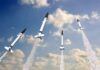 Multiple missiles launching into a cloudy sky