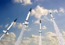 Multiple missiles launching into a cloudy sky