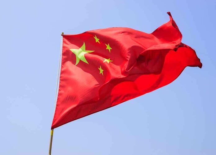 Chinese flag waving against a clear blue sky