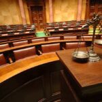 Celebrity Scandal: Beloved Actor’s Shocking Admission A courtroom with empty seats and a scale of justice in the foreground