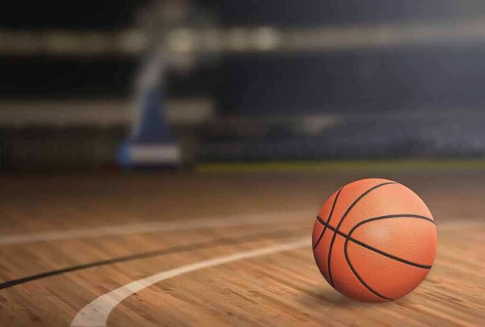 A basketball resting on a wooden court