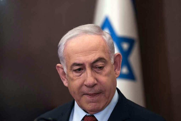 Man in suit with Israeli flag in background
