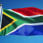 7,000 Afrikaners Welcomed — US Stuns Global Policy Experts South African flag waving against blue sky