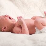 Chemical Abortion Floodgates Open – Unbelievable Shift A newborn baby lying on a soft blanket crying with a distressed expression