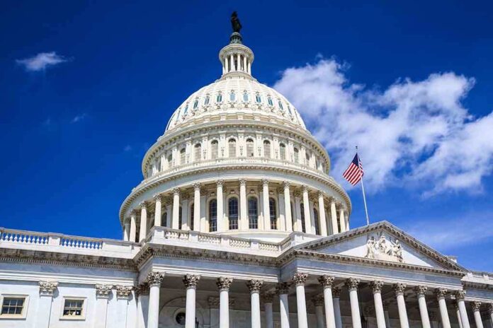 The US Capitol building with a dome and American flag against a blue sky