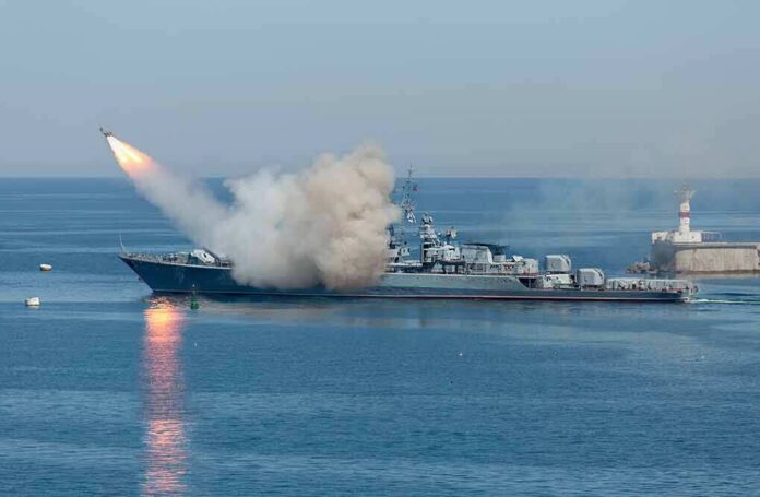 shutterstock_533229181 (2).jpg A military ship launching a missile into the ocean