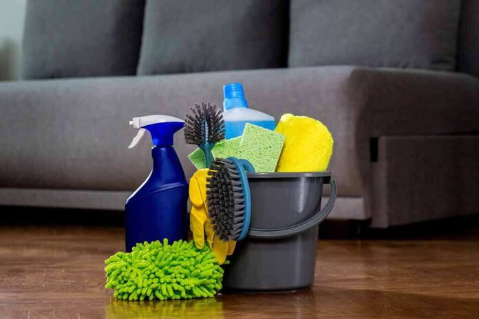A bucket filled with various cleaning supplies including sponges, brushes, and spray bottles