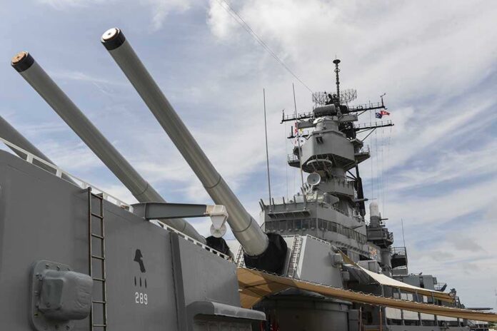 Close-up of a battleships naval guns and superstructure against a cloudy sky