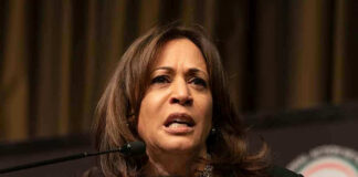 Woman speaking at a podium on stage.