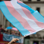 Shocking Gender Policy Rocks North Carolina Transgender flag waving in a crowded street.