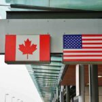 Canadian and American flags displayed at a border crossing