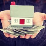 RISING Electric Bills Shock American Families Hands holding a small house model and cash bills