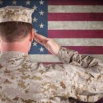 A soldier in uniform saluting in front of the American flag