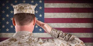 A soldier in uniform saluting in front of the American flag