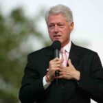 BOMBSHELL: Clintons Ordered to Testify on Epstein A man in a suit speaking into a microphone at an outdoor event