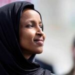State of the Union Showdown: Hecklers Clash with Trump Woman wearing a black hijab looking thoughtfully during an outdoor event