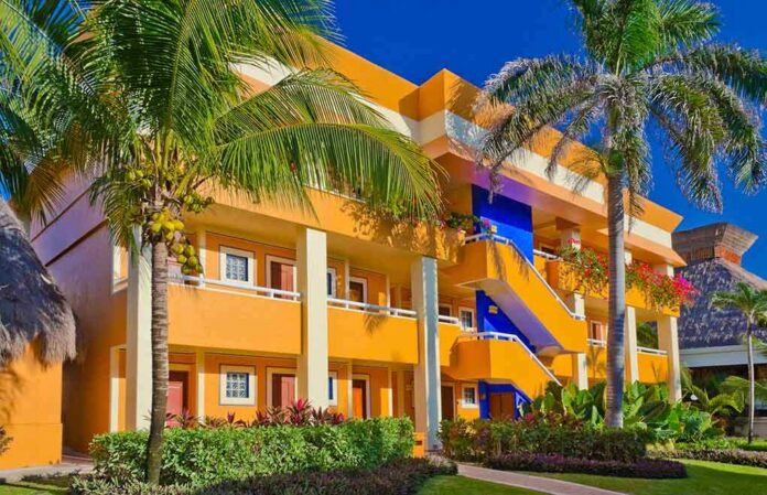 Colorful resort building surrounded by palm trees and lush greenery