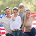 $400K Income NEEDED for Child Care? Unbelievable! A family of four posing outdoors with an American flag