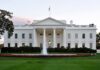 The White House with a fountain in the foreground and an American flag flying