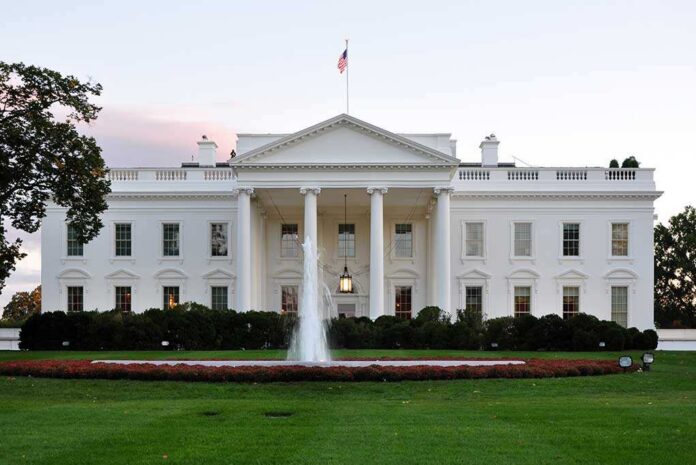 The White House with a fountain in the foreground and an American flag flying