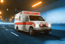 Ambulance driving through a brightly lit tunnel.