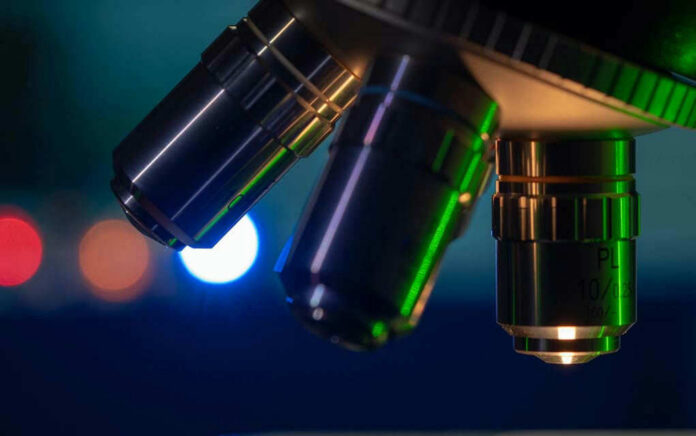 1854872740 Closeup of microscope lenses with colorful background